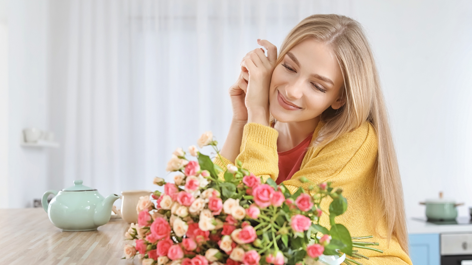 Молодая блондинка с букетом роз на столе