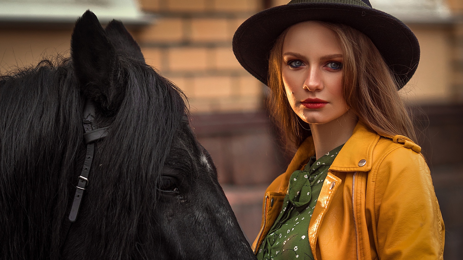 Молодая девушка в черной шляпе с конем 