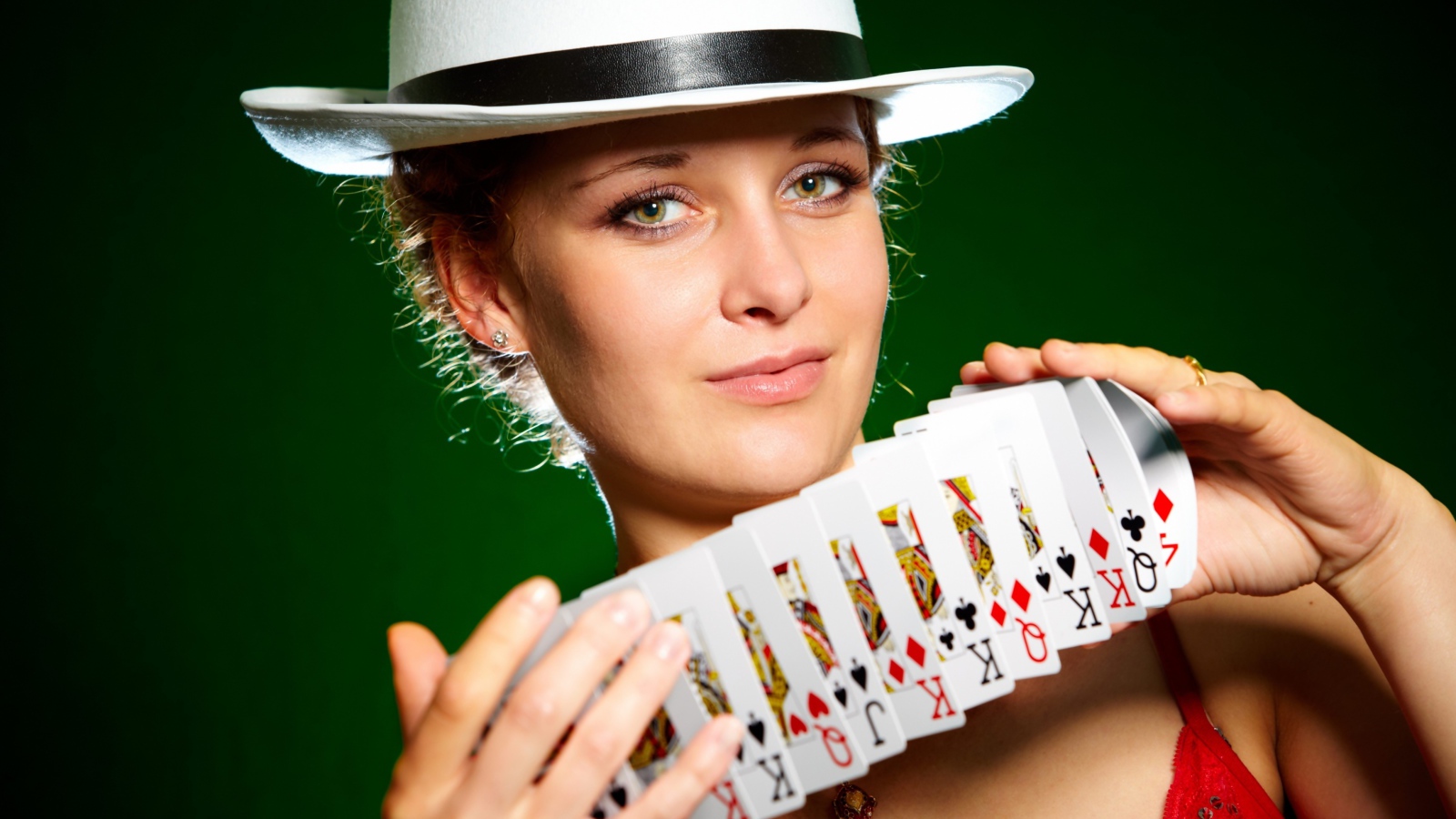 Молодая девушка в шляпе с картами в руках