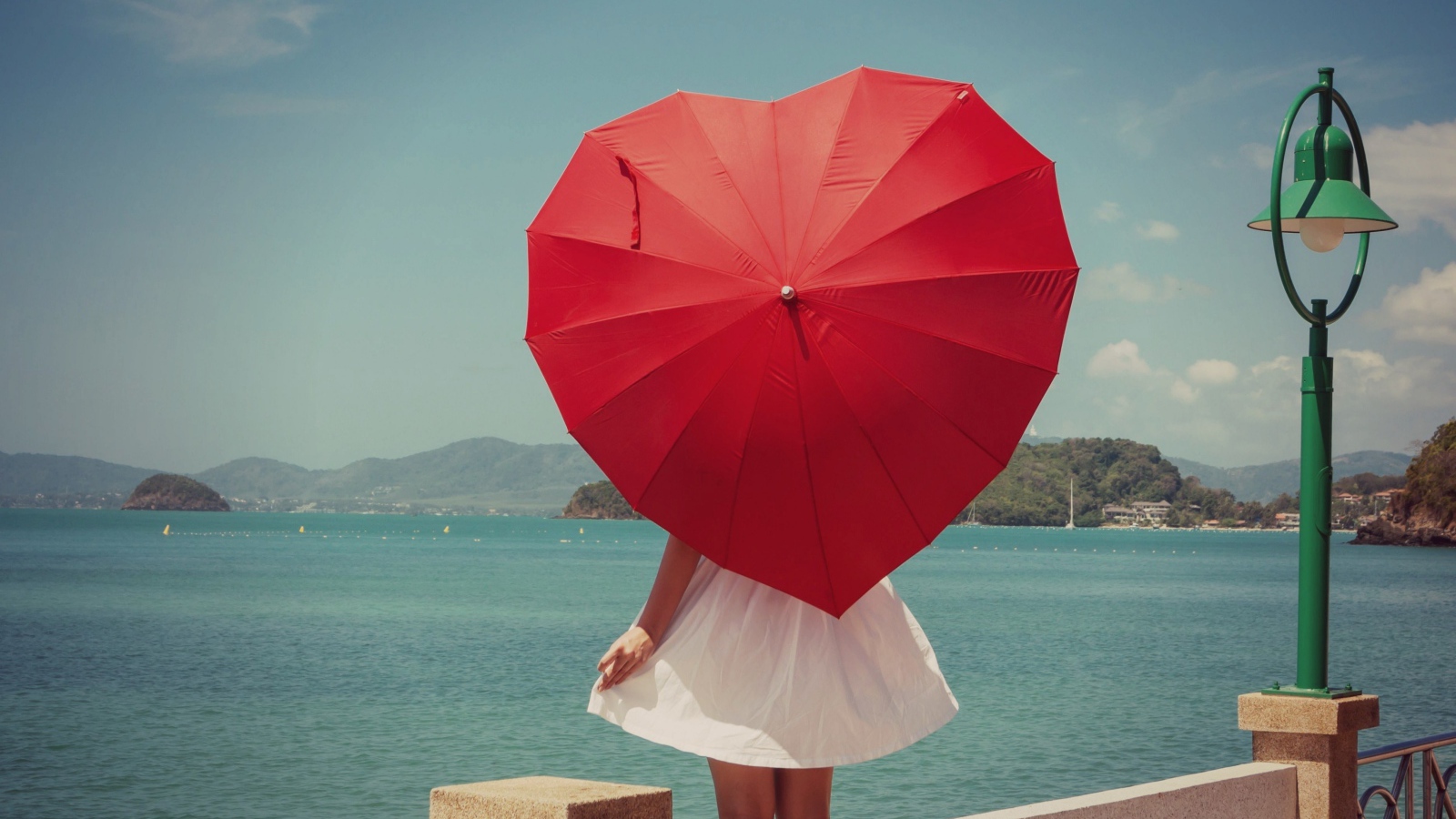 Молодая девушка с красным зонтом в форме сердца