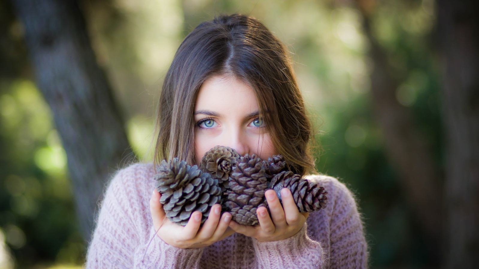 Молодая девушка с шишками в руках