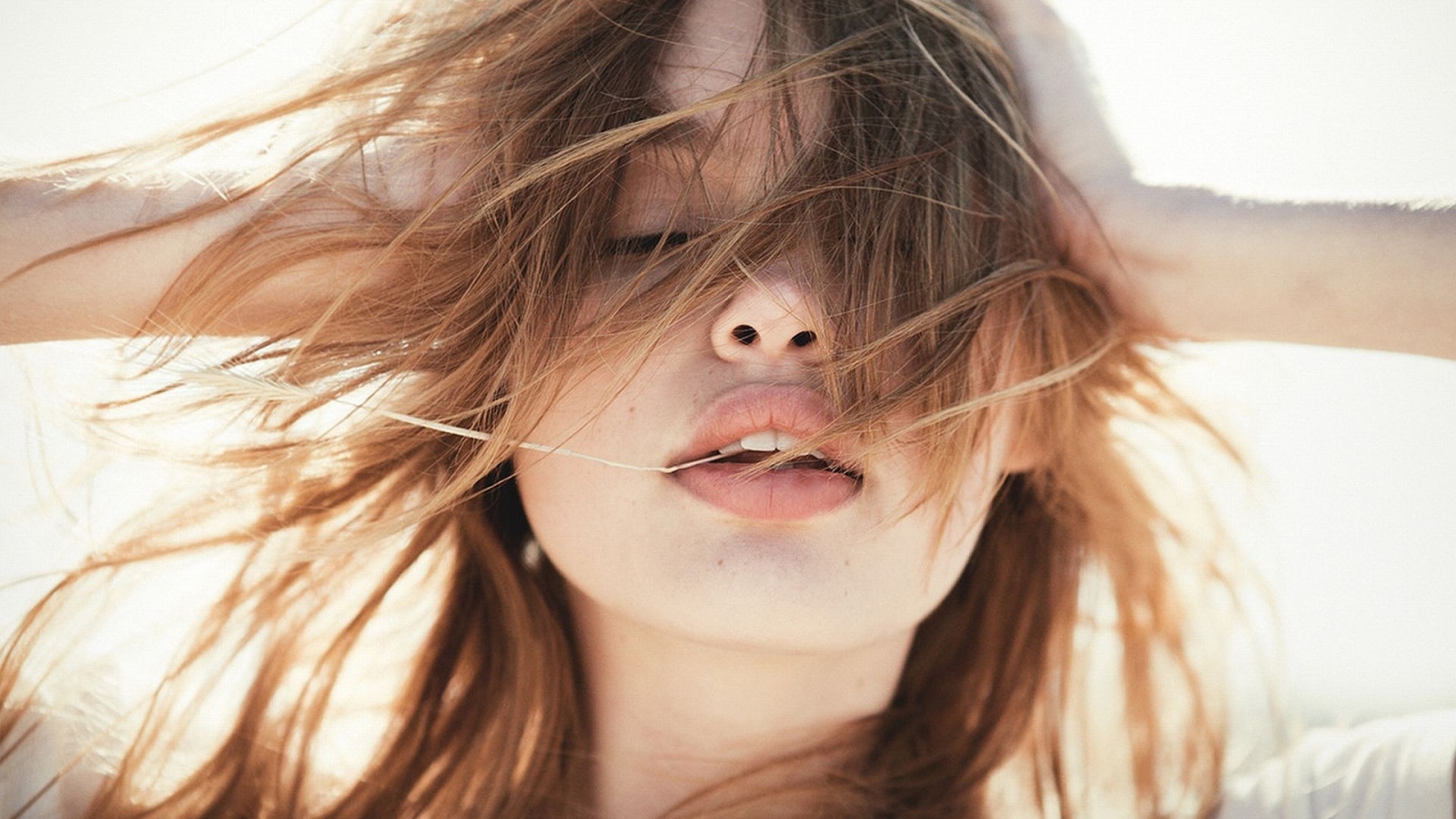 Молодая девушка с распущенными волосами на ветру