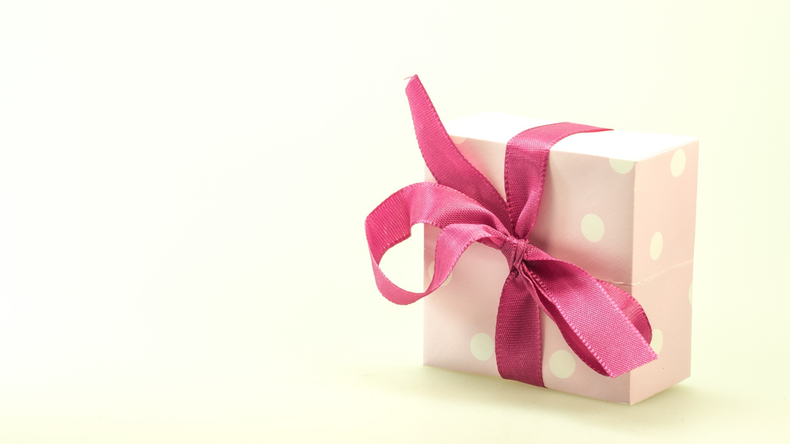 Подарочная коробка с розовым бантом на белом фоне