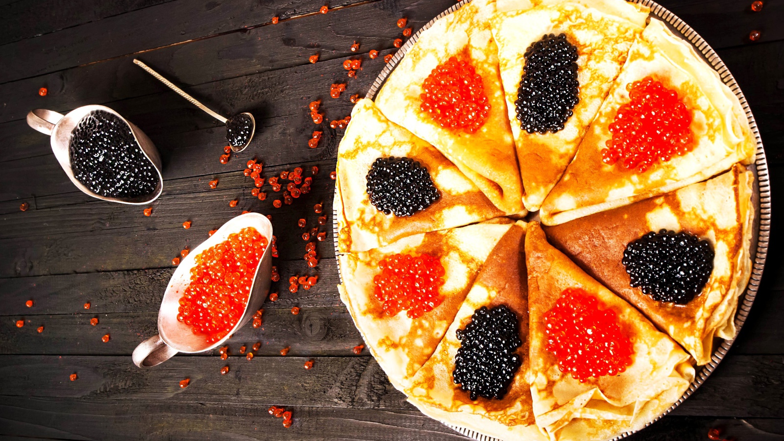 Блины с черной и красной икрой на деревянном столе на Масленицу