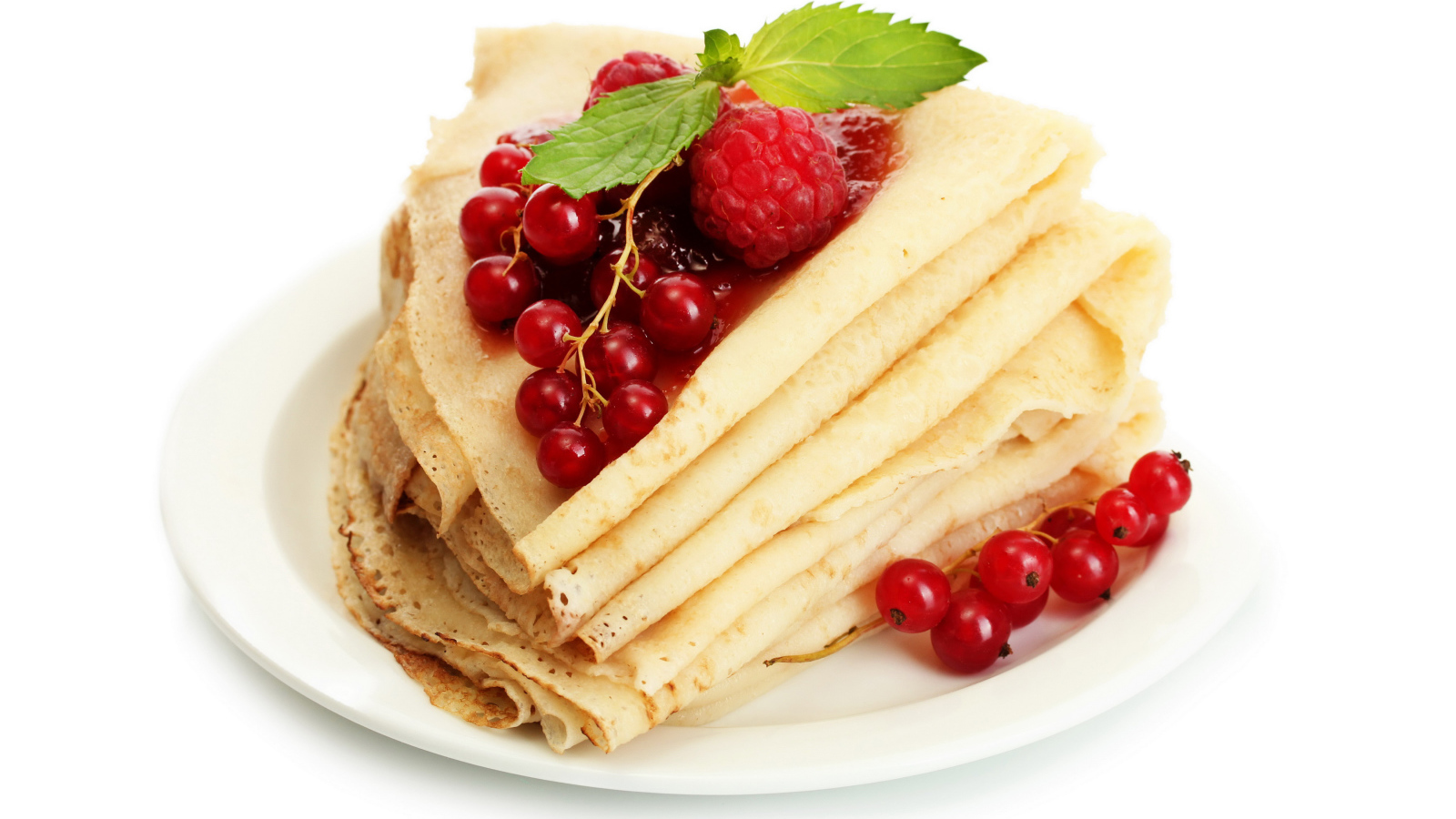 Тонкие блины с малиной и красной смородиной на белом фоне на Масленицу