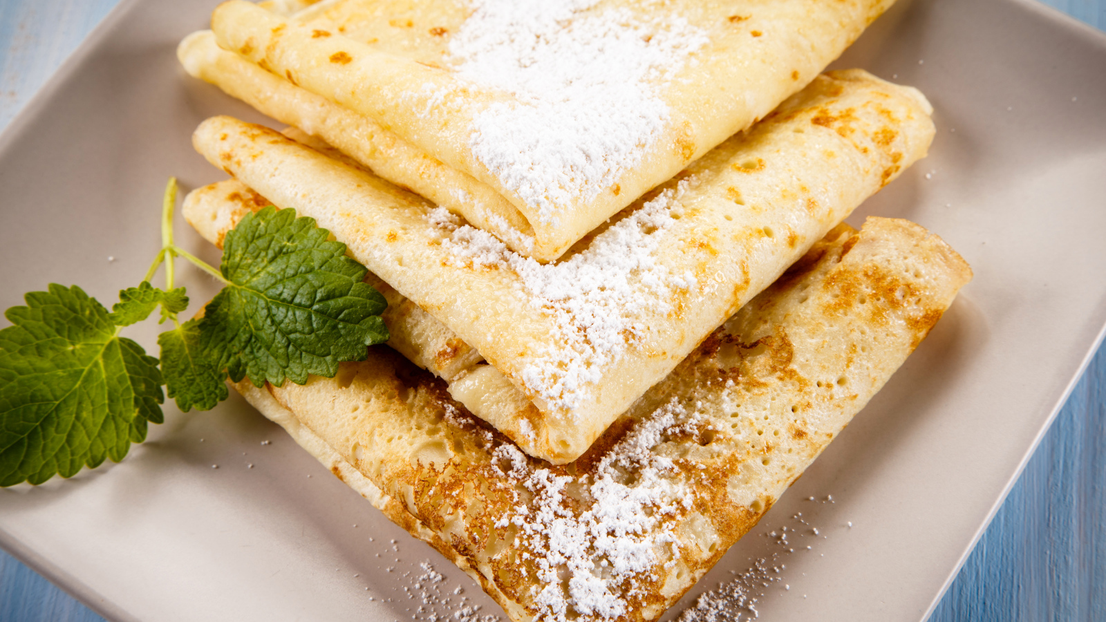 Тонкие блинчики с сахарной пудрой и листиком мяты на Масленицу 2018