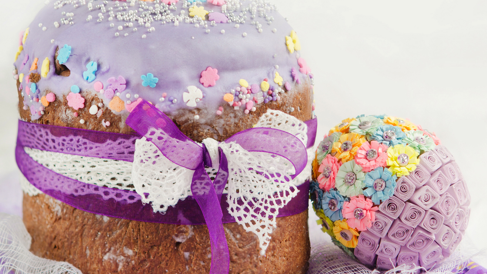 Красивый пасхальный кулич с лентой и декоративным яйцом на праздник Пасха