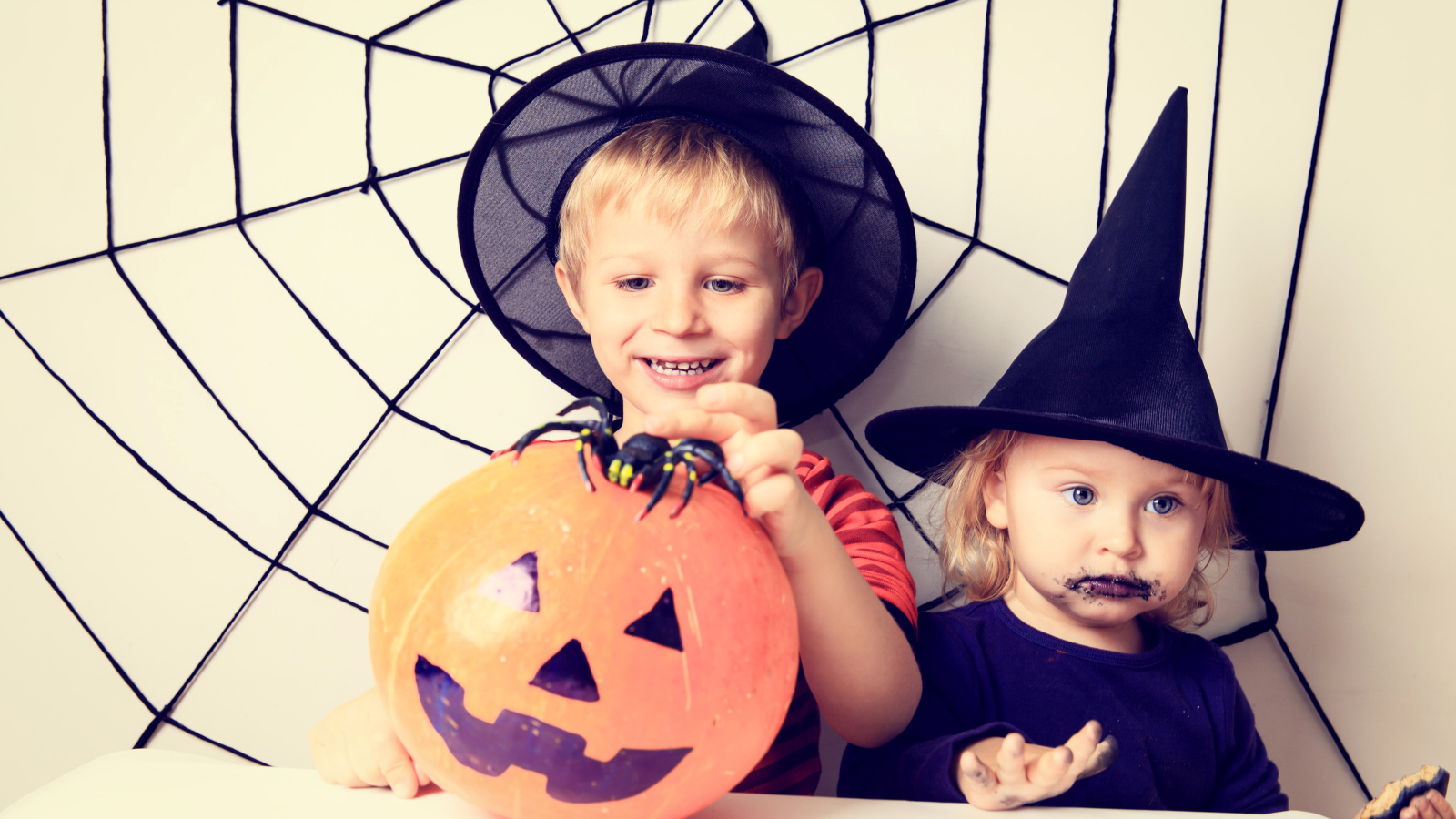 Маленькие мальчик и девочка в костюмах на Хэллоуин