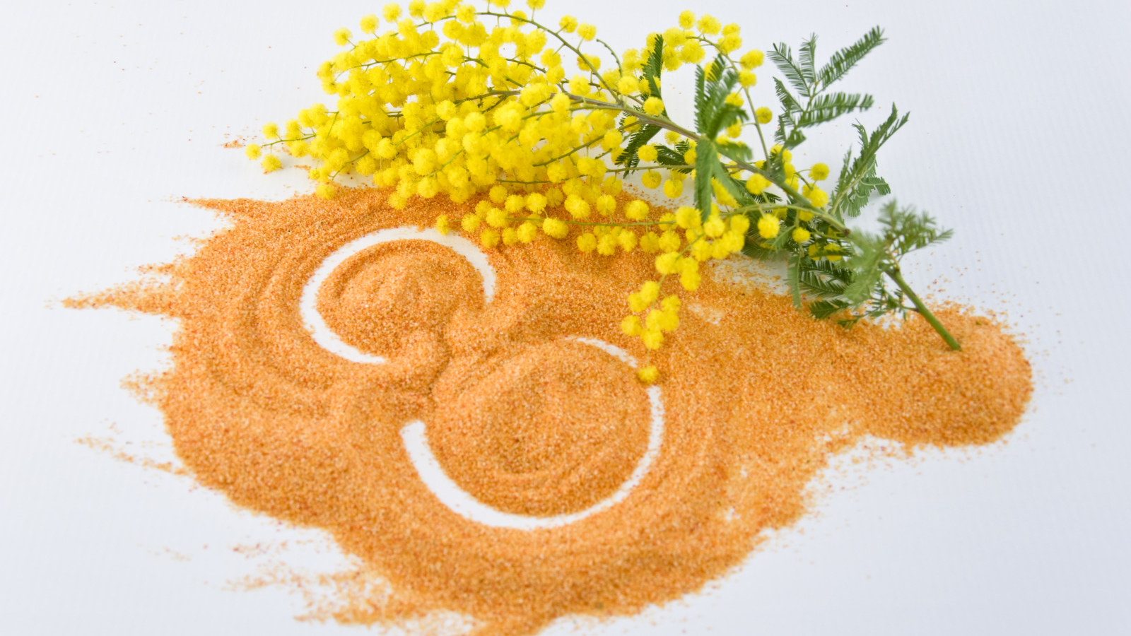 Цифра 8 на песке с веткой мимозы на Международный женский день 8 марта