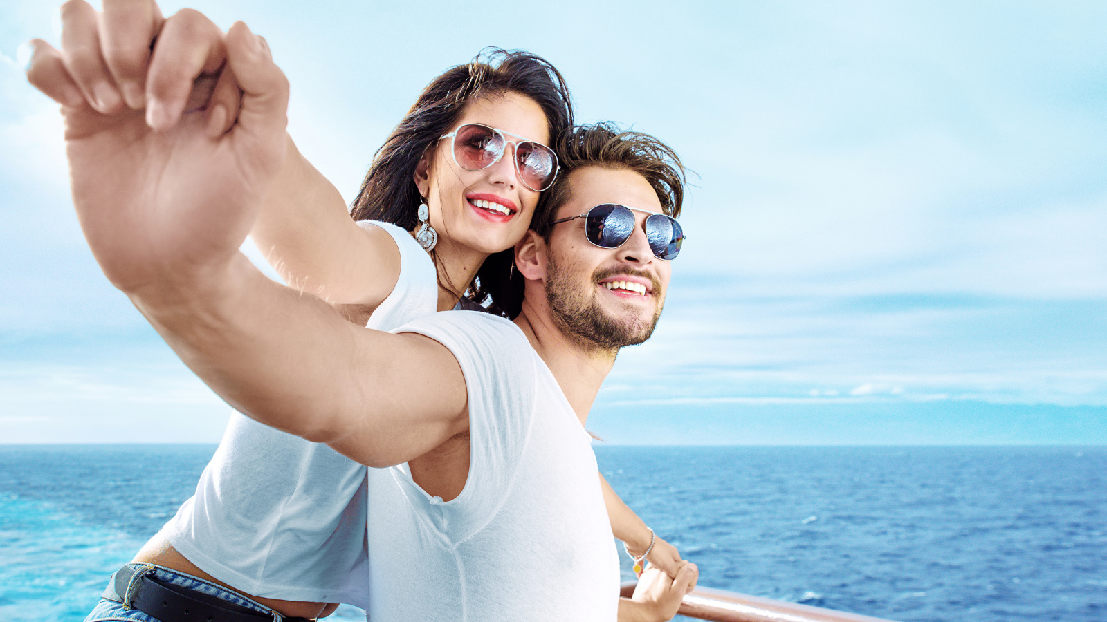 Влюбленная пара держится за руки на фоне моря