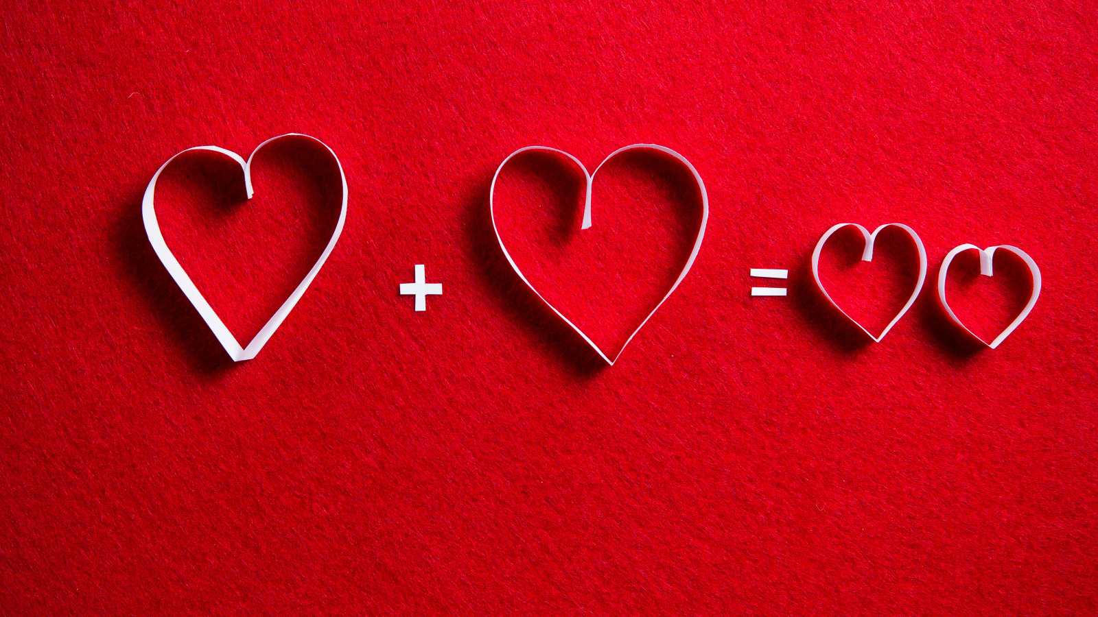 Белые бумажные сердечки на красном фоне