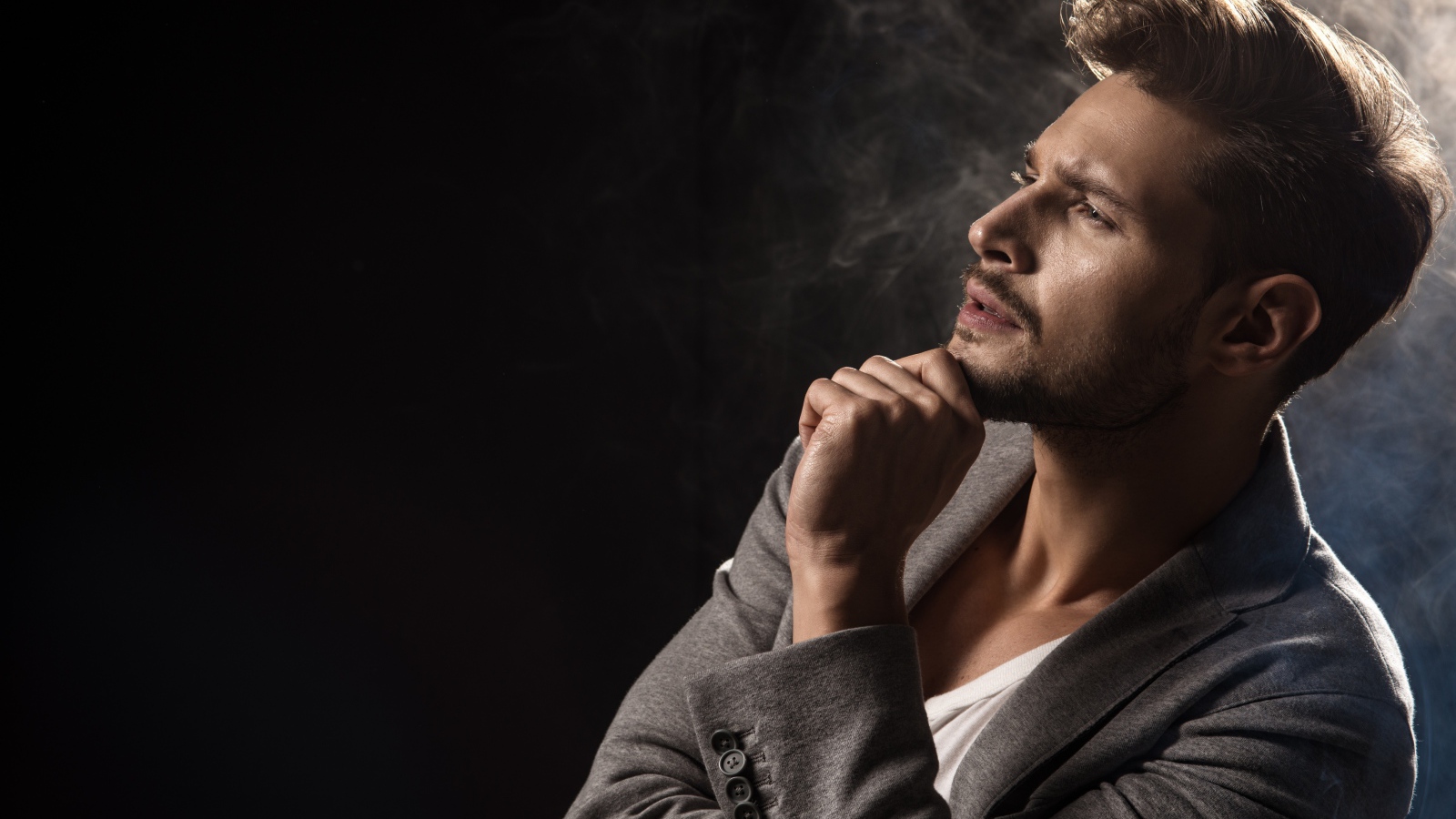 Красивый задумчивый мужчина в сером пиджаке