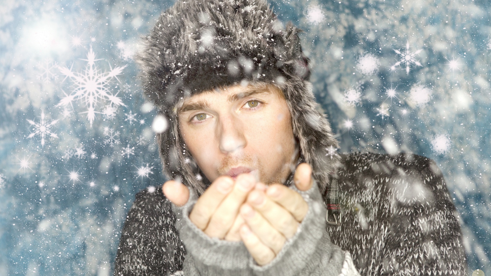 Молодой парень в теплой шапке мерзнет зимой