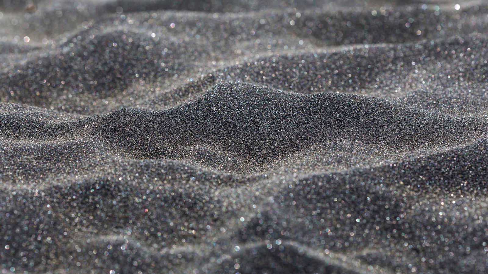 Блестящий черный песок крупным планом