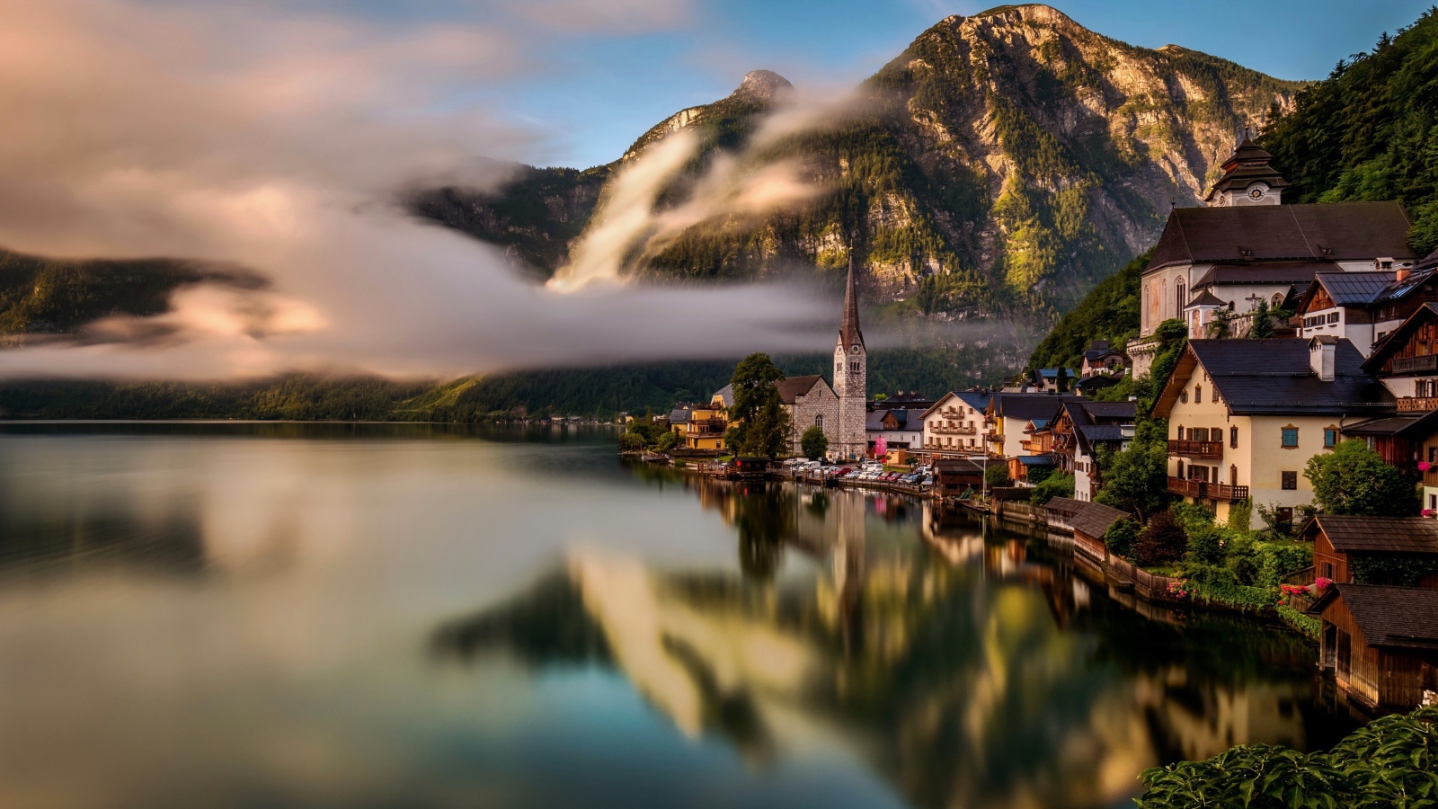 Город Гальштат над туманным озером в горах Альпы, Австрия