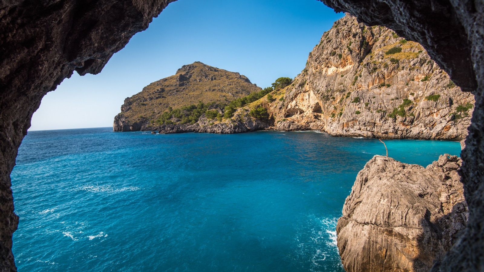 Скалы в морском заливе под голубым небом