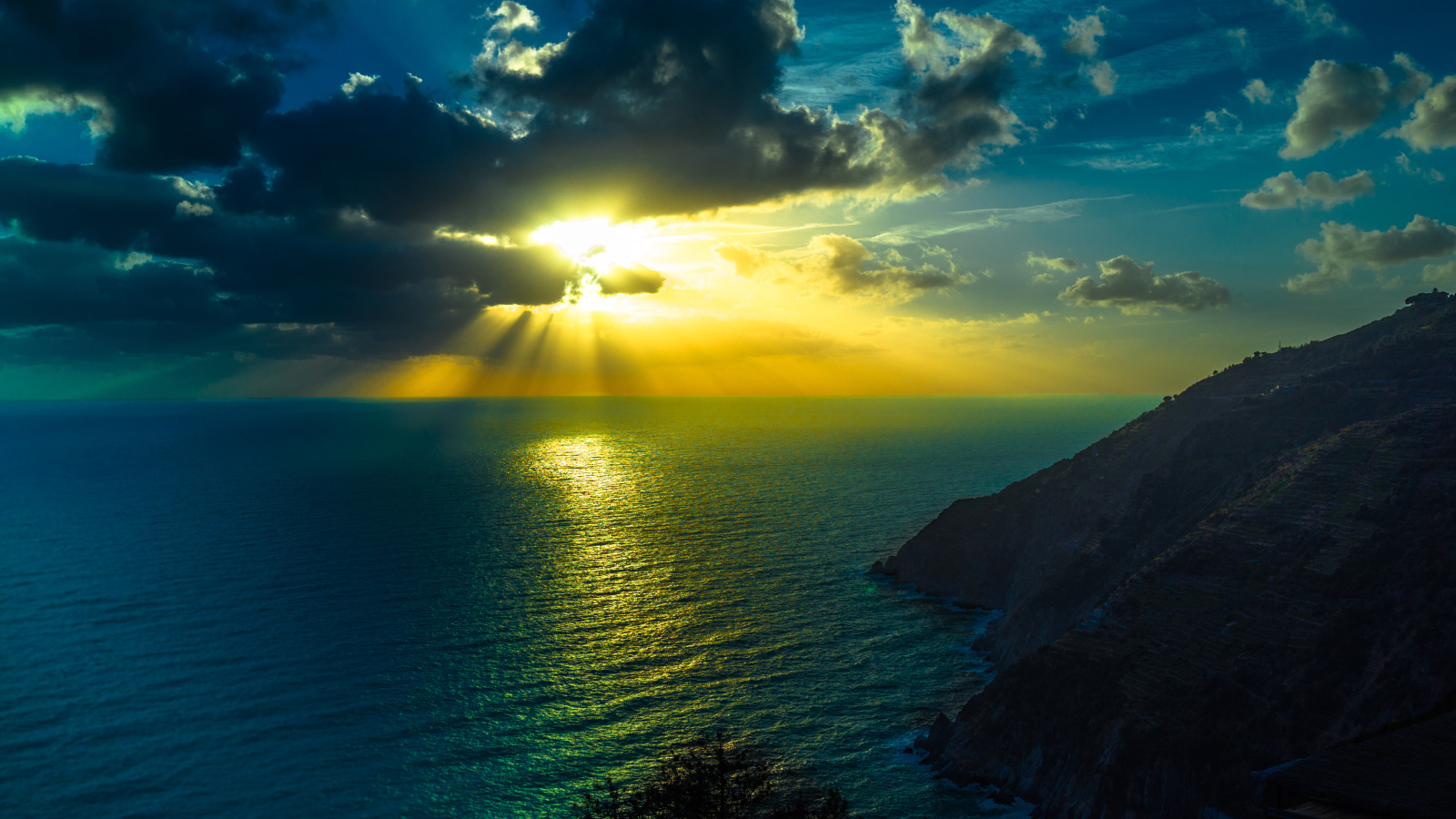 Лучи солнца пробиваются сквозь облака над океаном