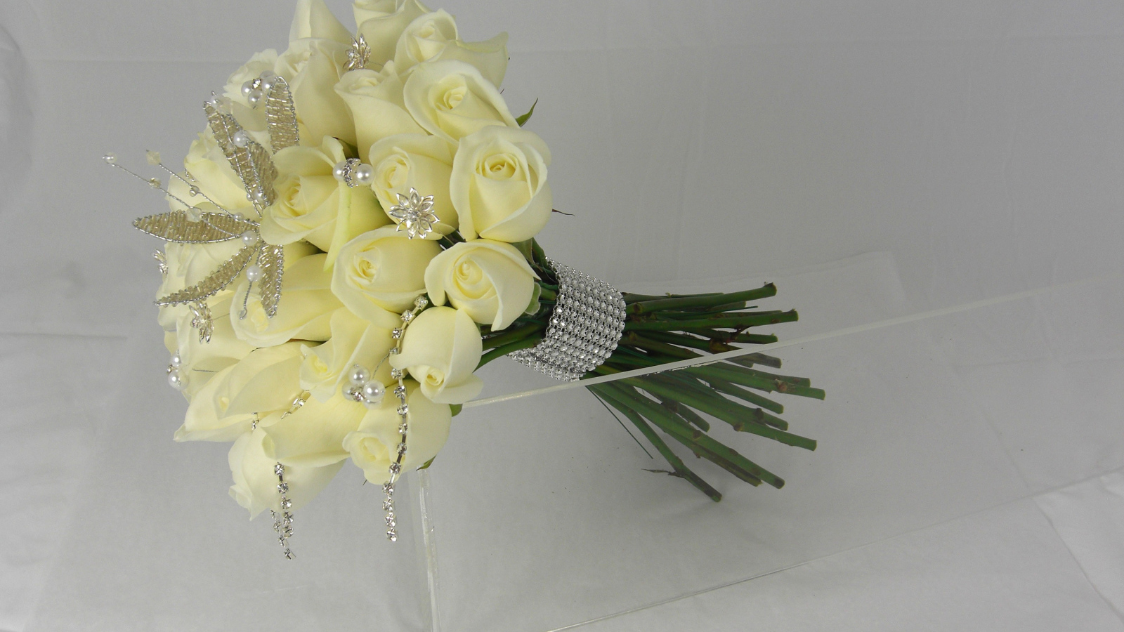 A bouquet of delicate white roses with ornaments on a gray background