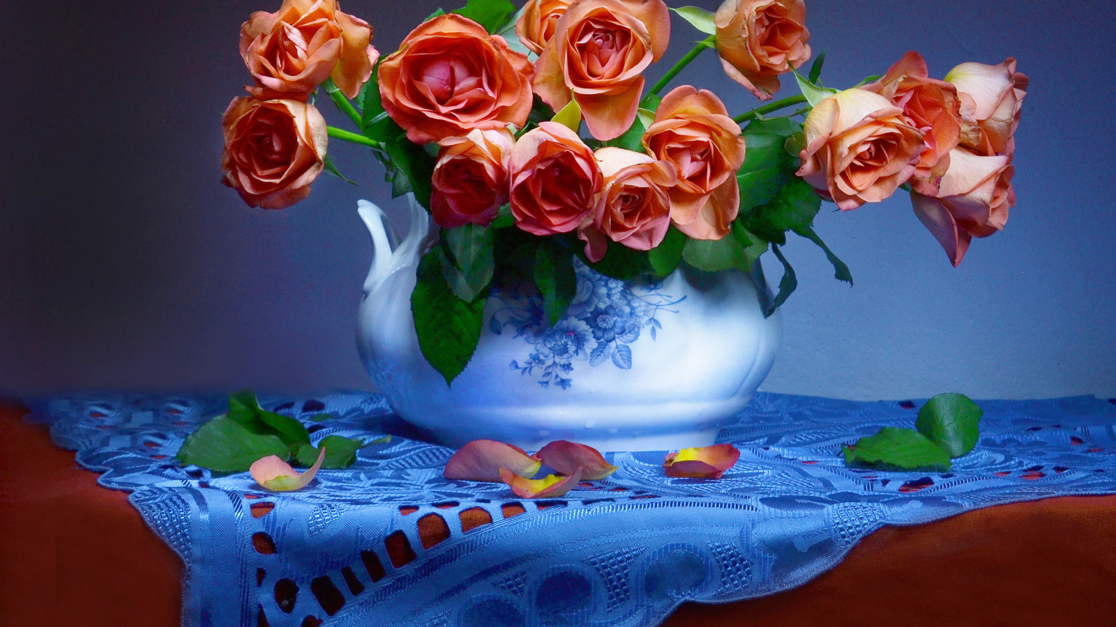 Букет оранжевых роз в вазе на столе 