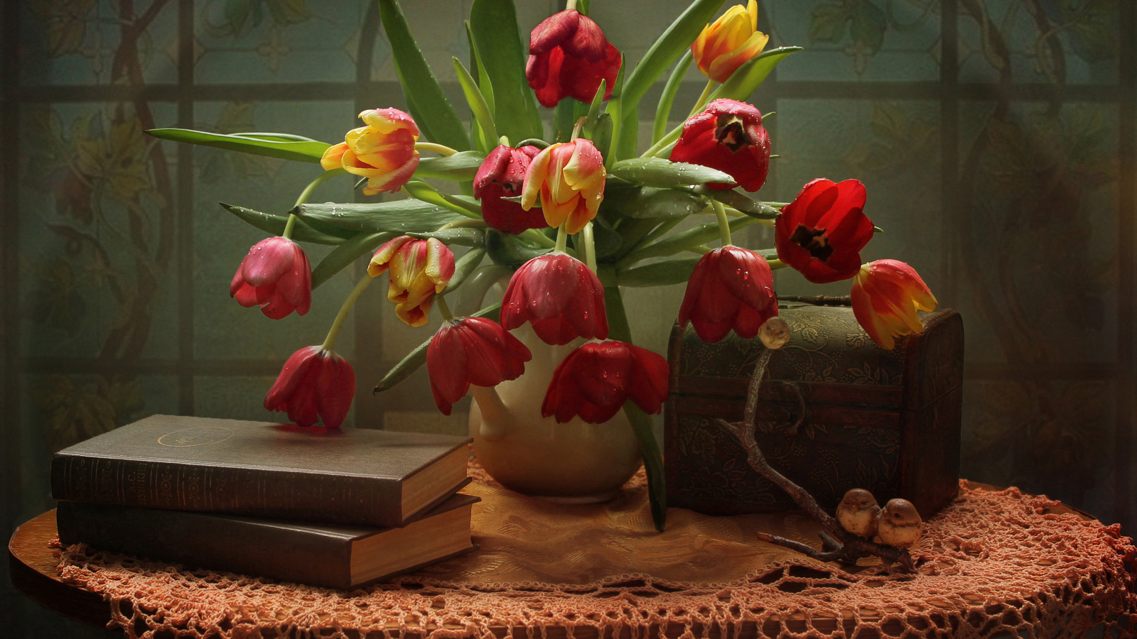 Букет тюльпанов на столе с книгами и шкатулкой
