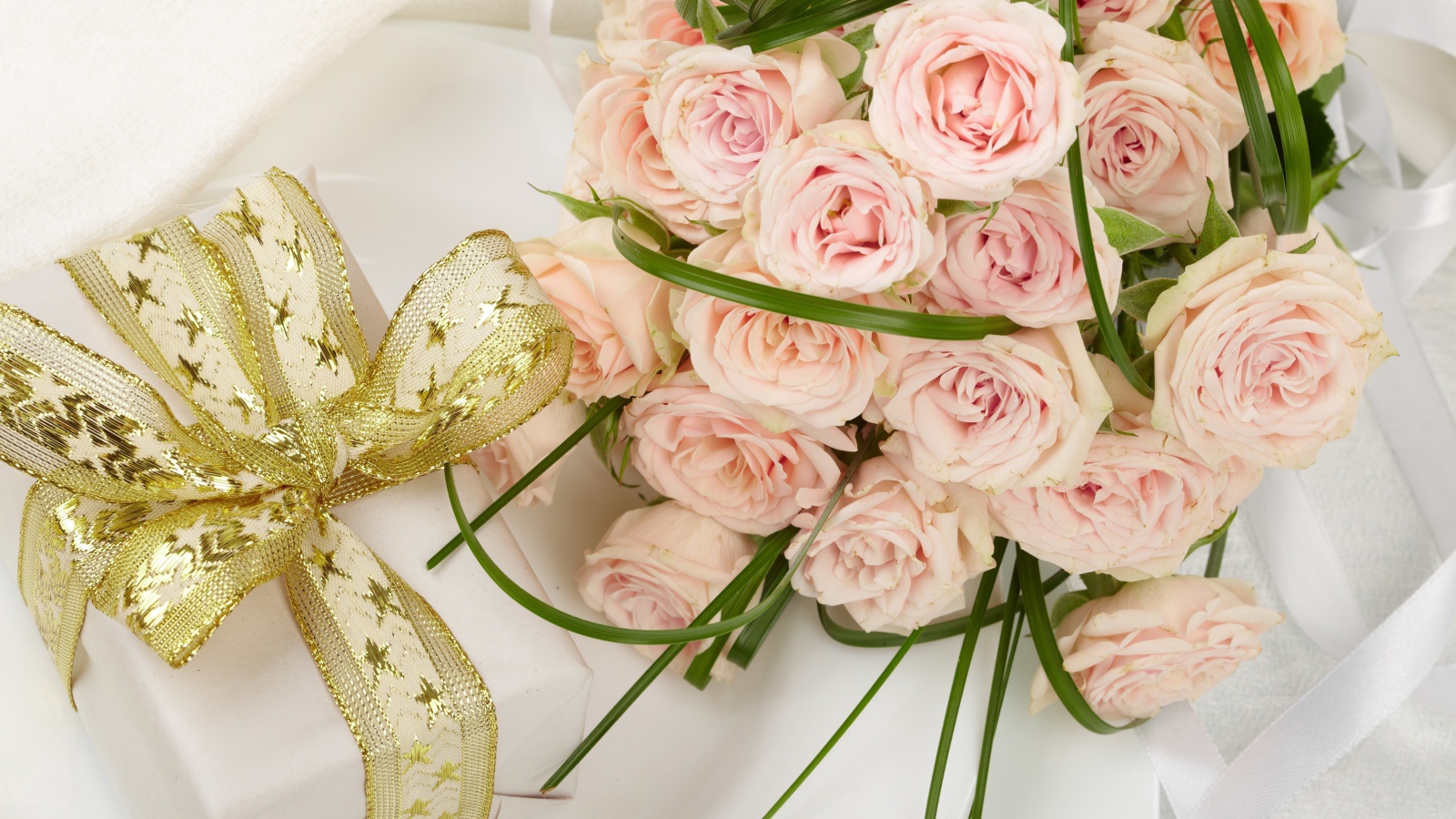 Букет розовых роз и подарок с красивым бантом