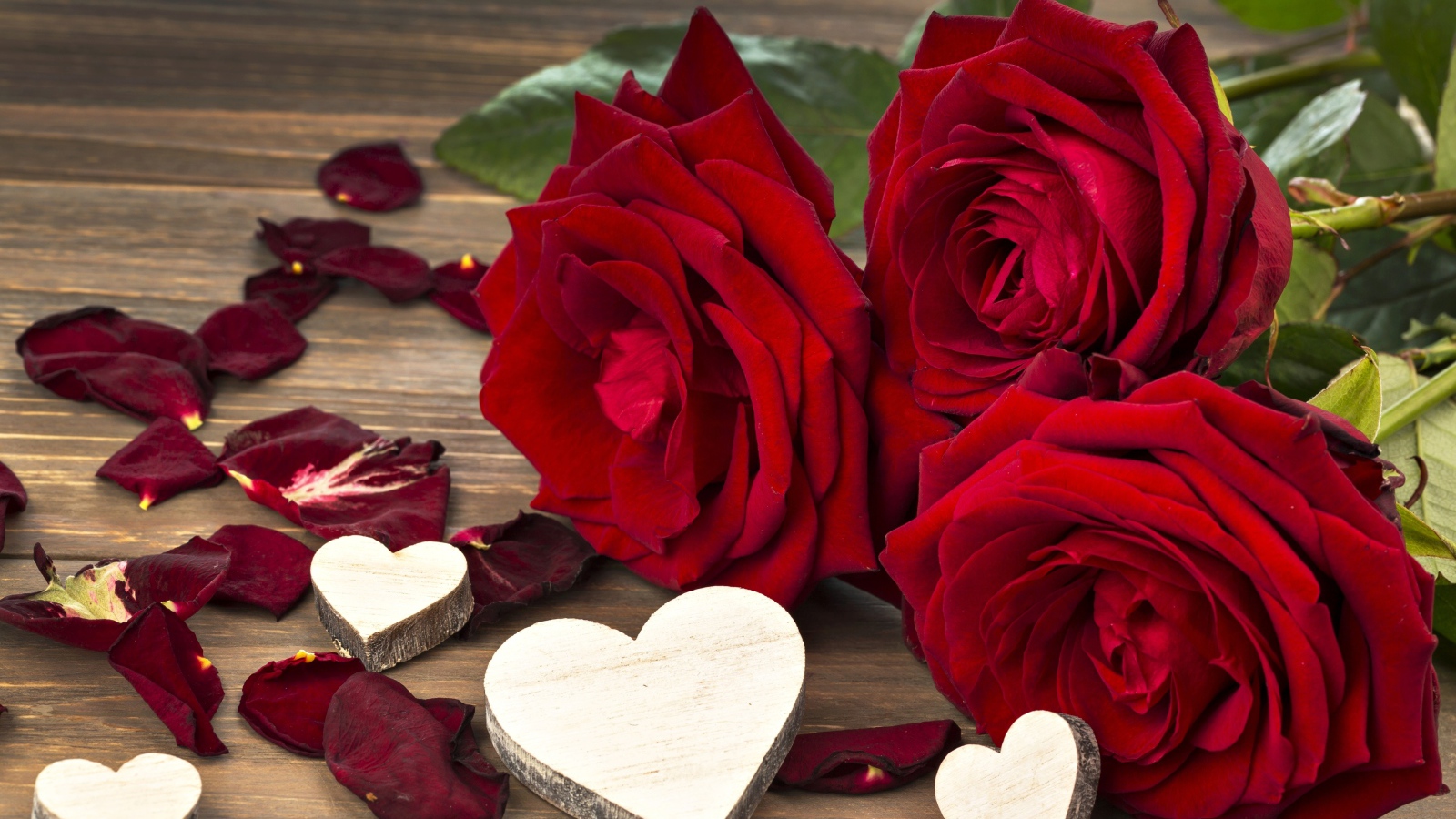 Три крупные красные розы с деревянными сердечками