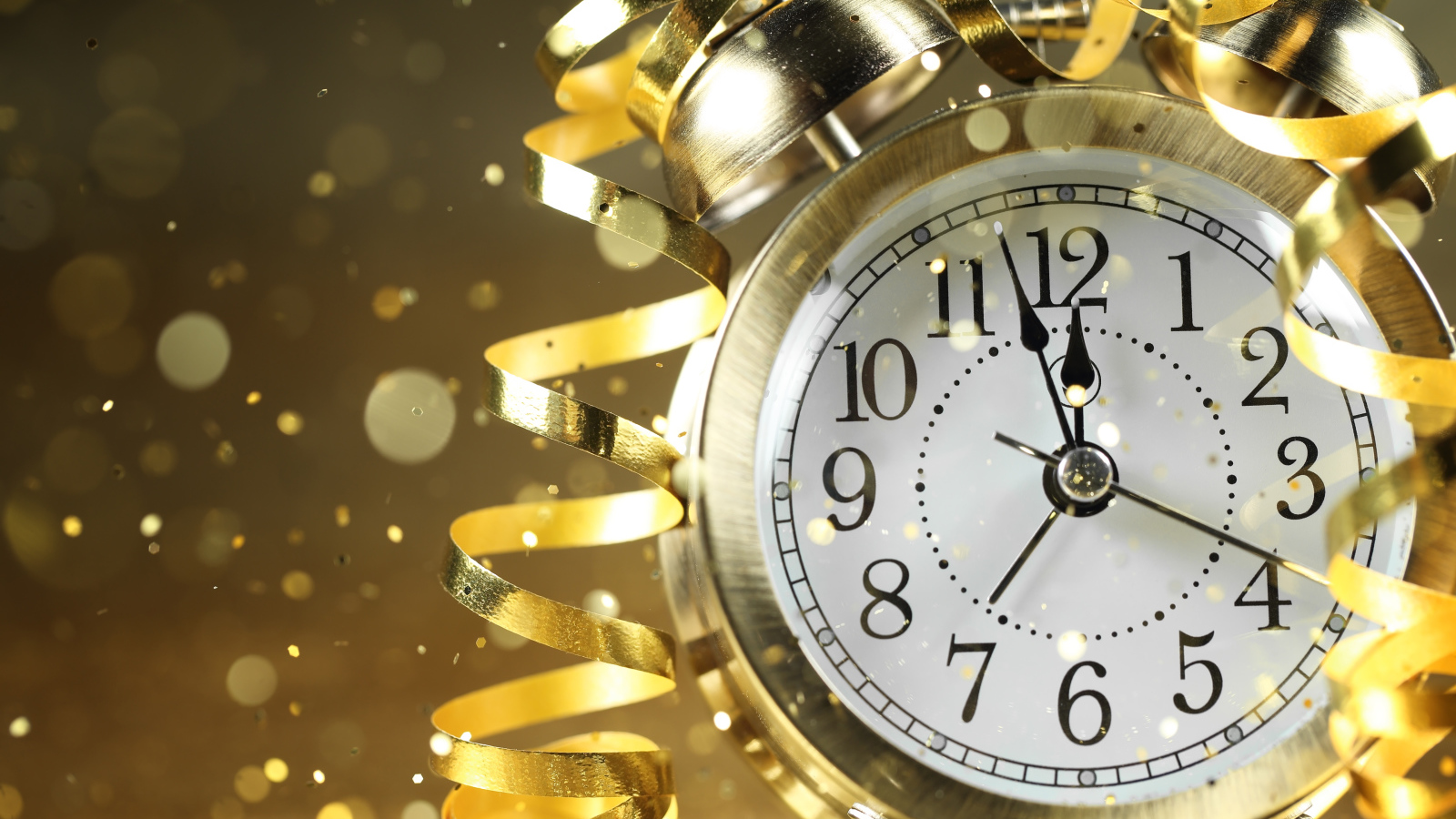 Стрелки новогоднего будильника с серпантином доходят до двенадцати ночи