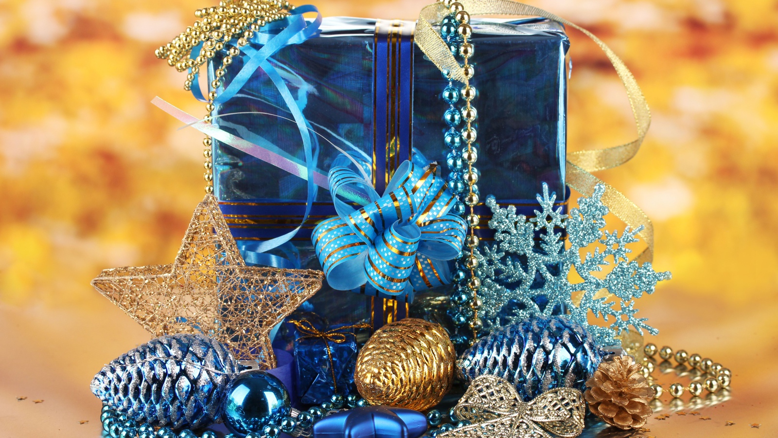 Большой подарок в голубой упаковке с украшениями на Новый год 