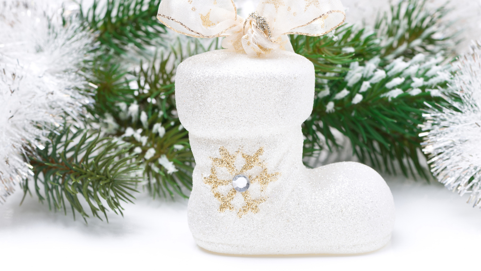 Ботинок с бантом и зеленая еловая ветка на белом фоне на Новый год 