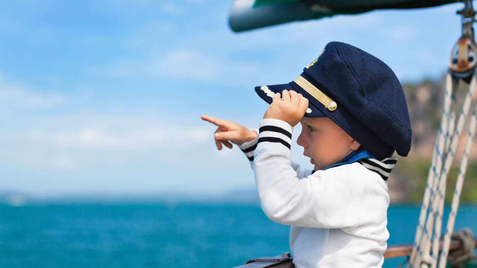 Маленький мальчик в форме капитана на корабле