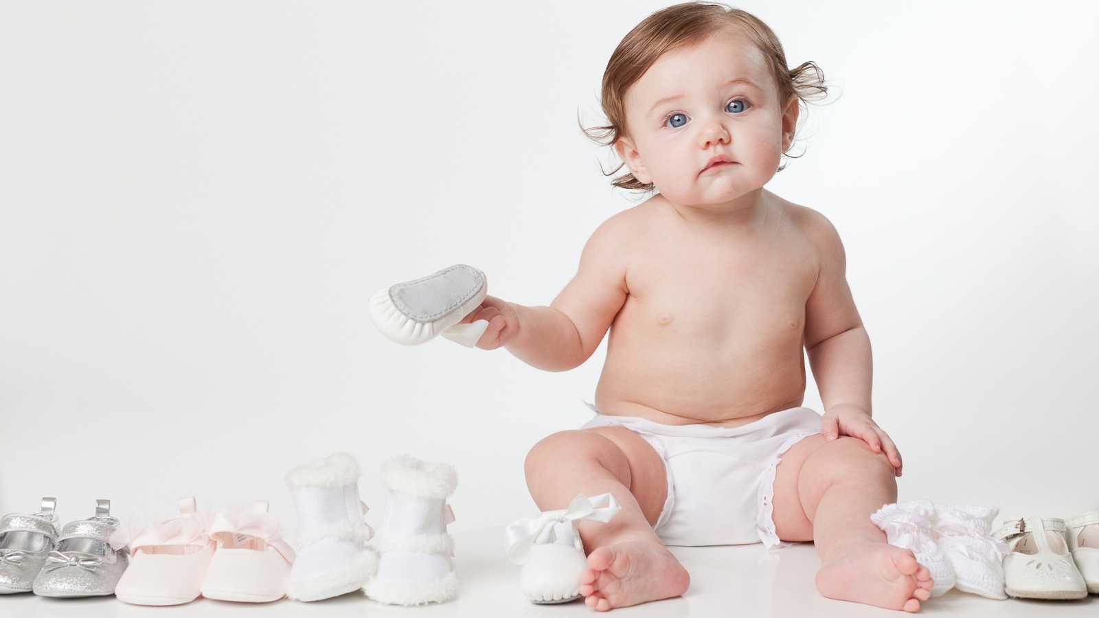 Маленький грудной ребенок с детской обувью
