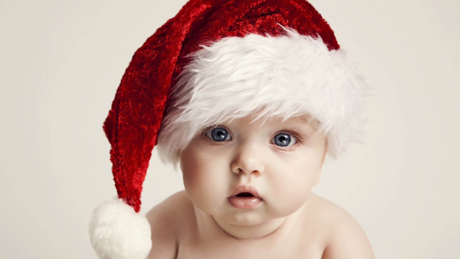 Голубоглазый малыш в красной шапке деда мороза