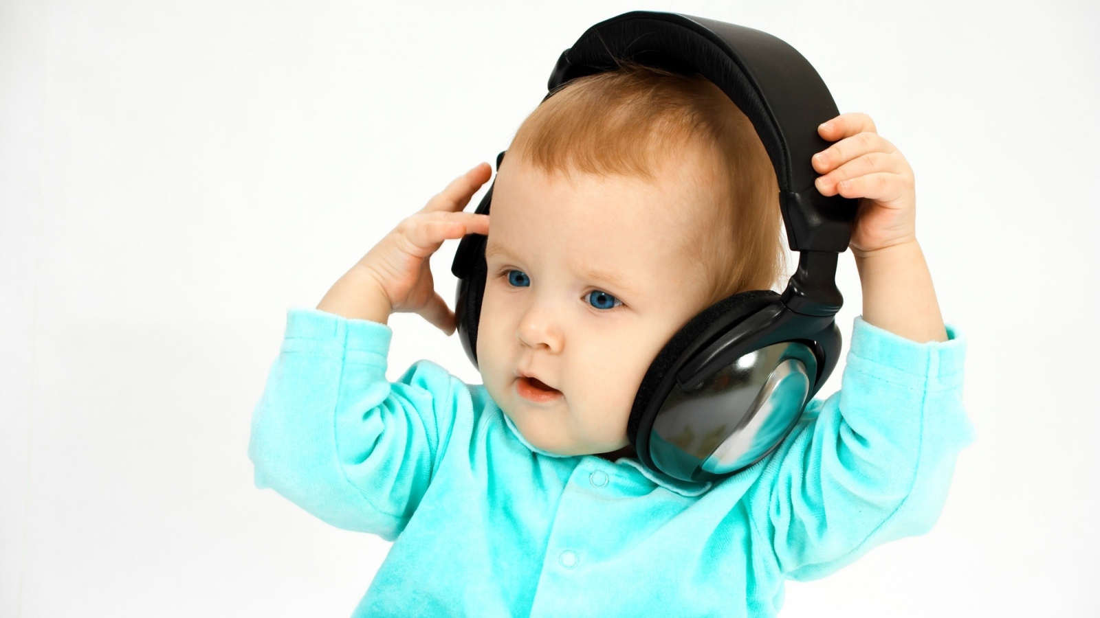 Голубоглазый мальчик в больших наушниках на белом фоне