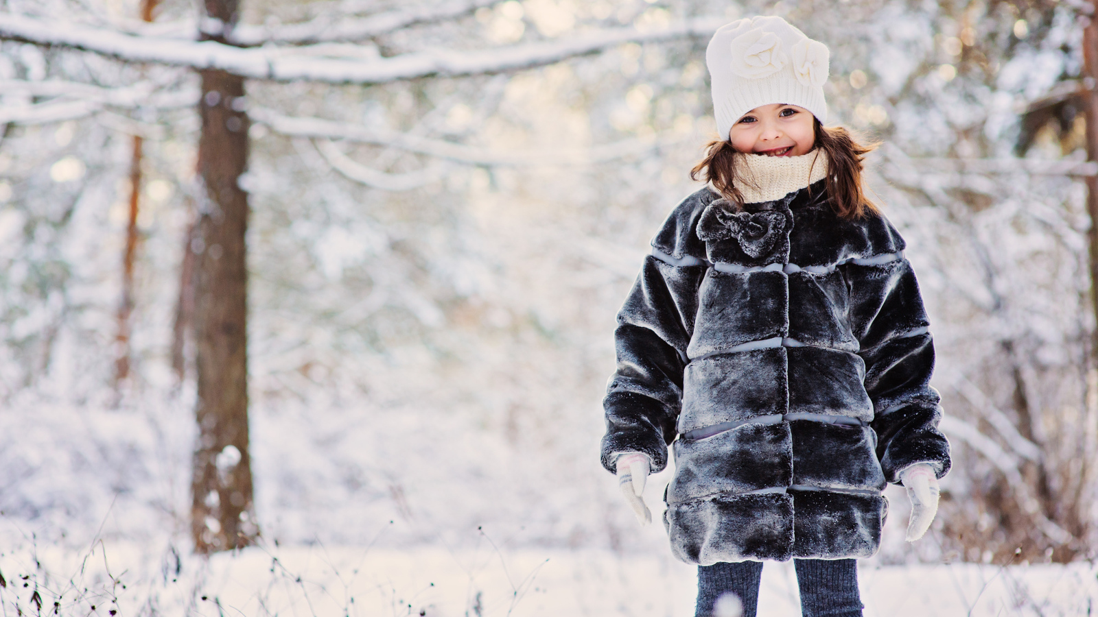 Милая маленькая девочка в шубе зимой