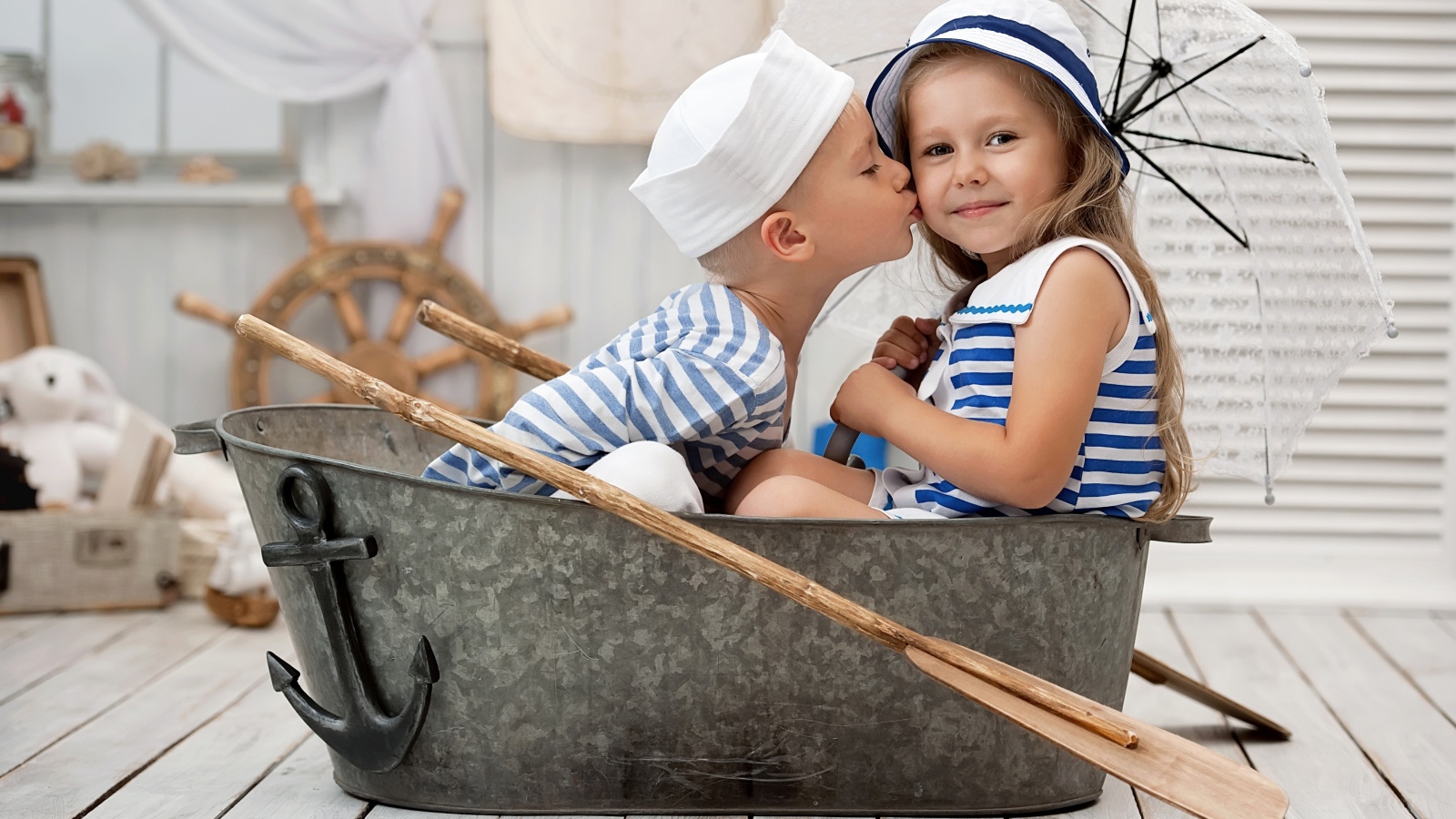 Маленькие мальчик и девочка сидят в железном корыте