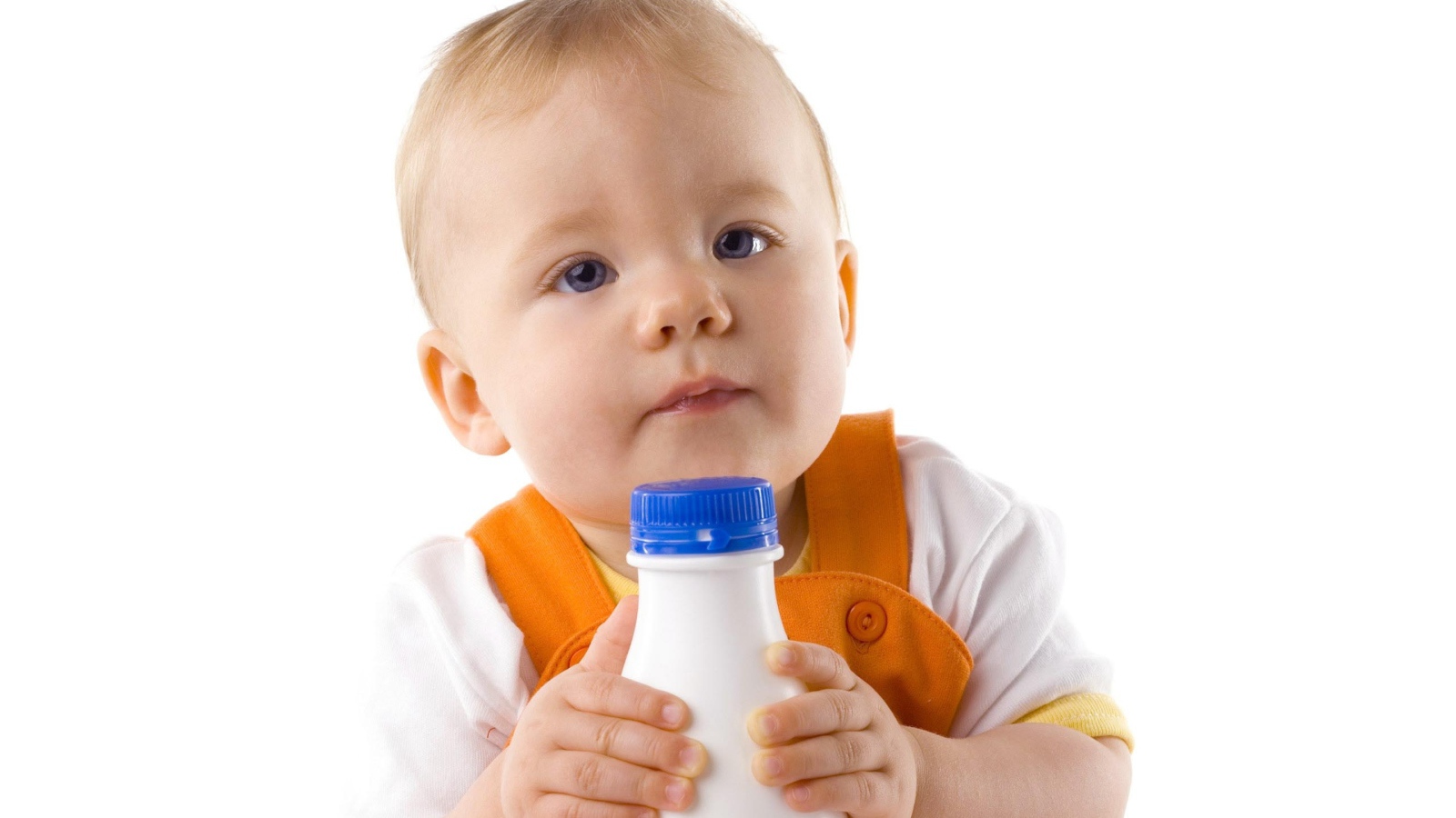 Маленький мальчик с бутылкой молока на белом фоне