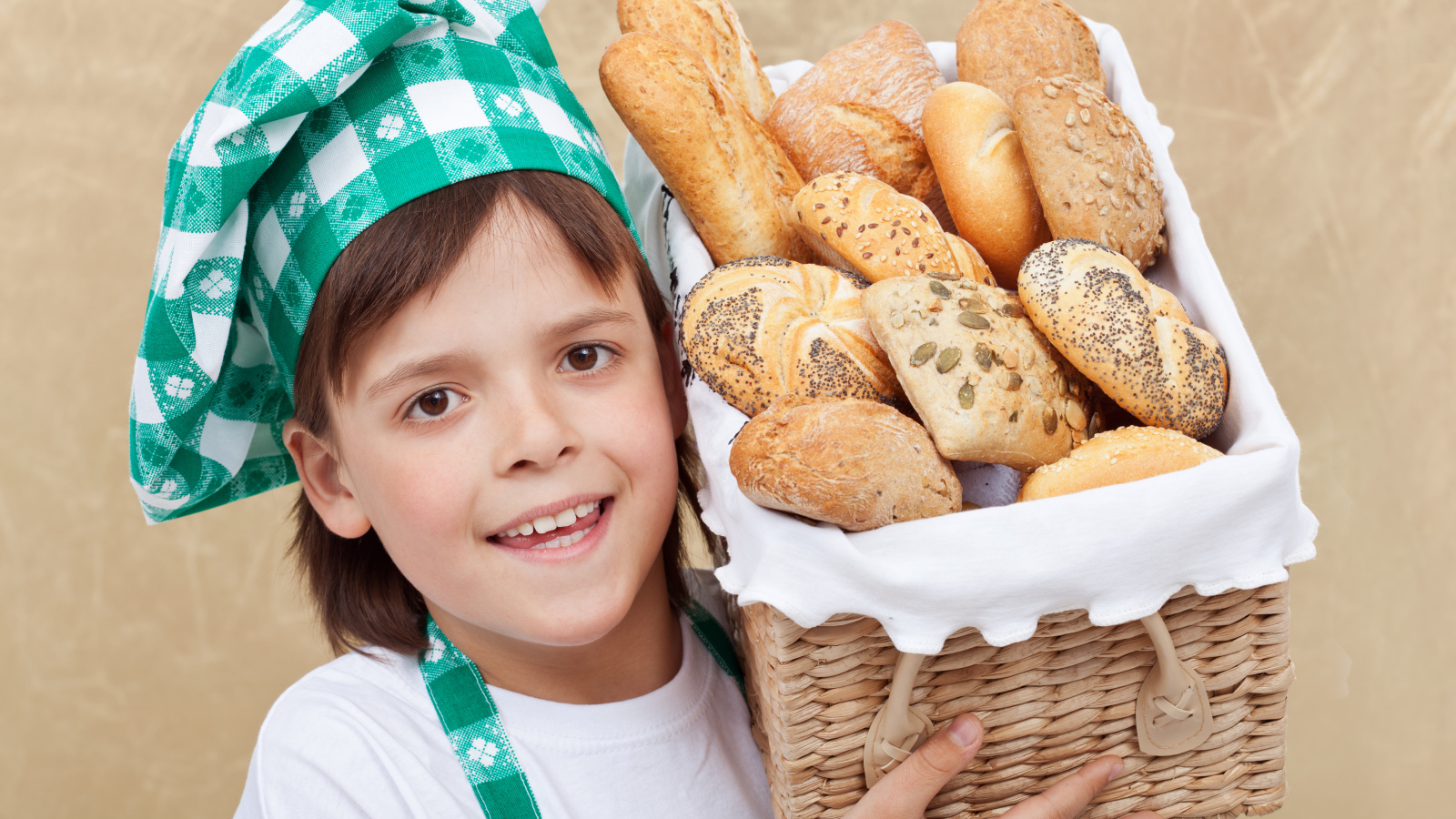 Маленькой поваренок с корзиной свежей выпечки 