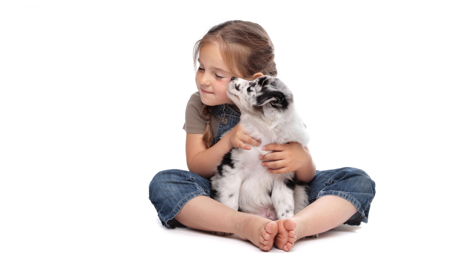 Маленькая девочка с щенком на белом фоне
