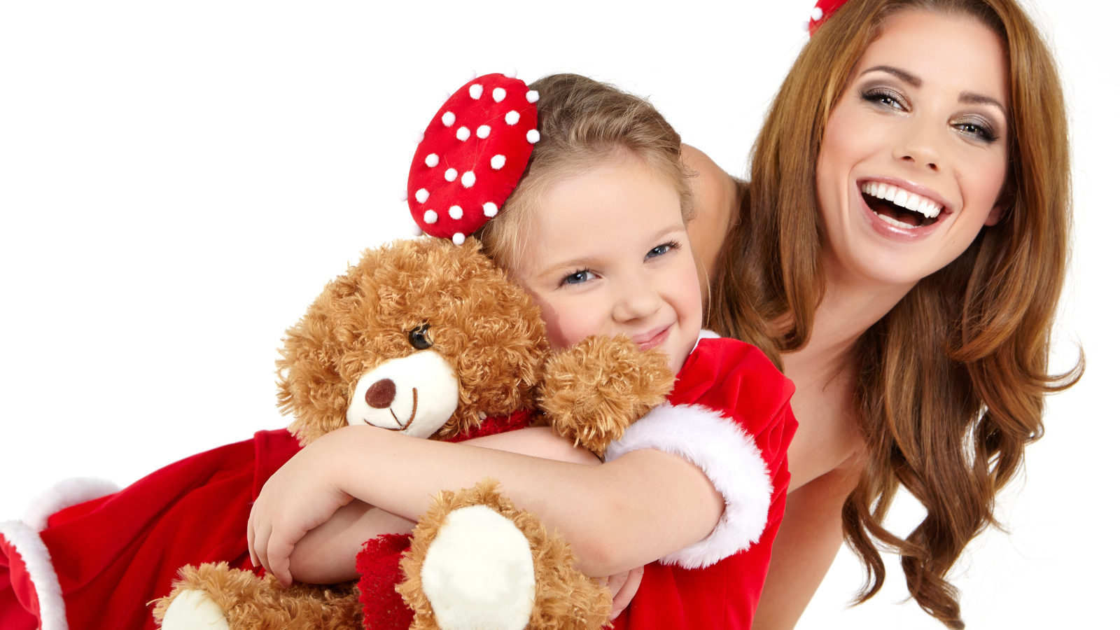 Маленькая девочка с мамой обнимает игрушечного медвежонка