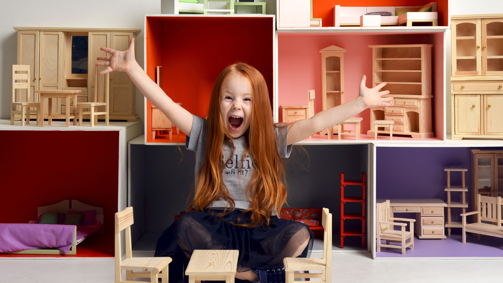 Маленькая девочка с игрушечной мебелью