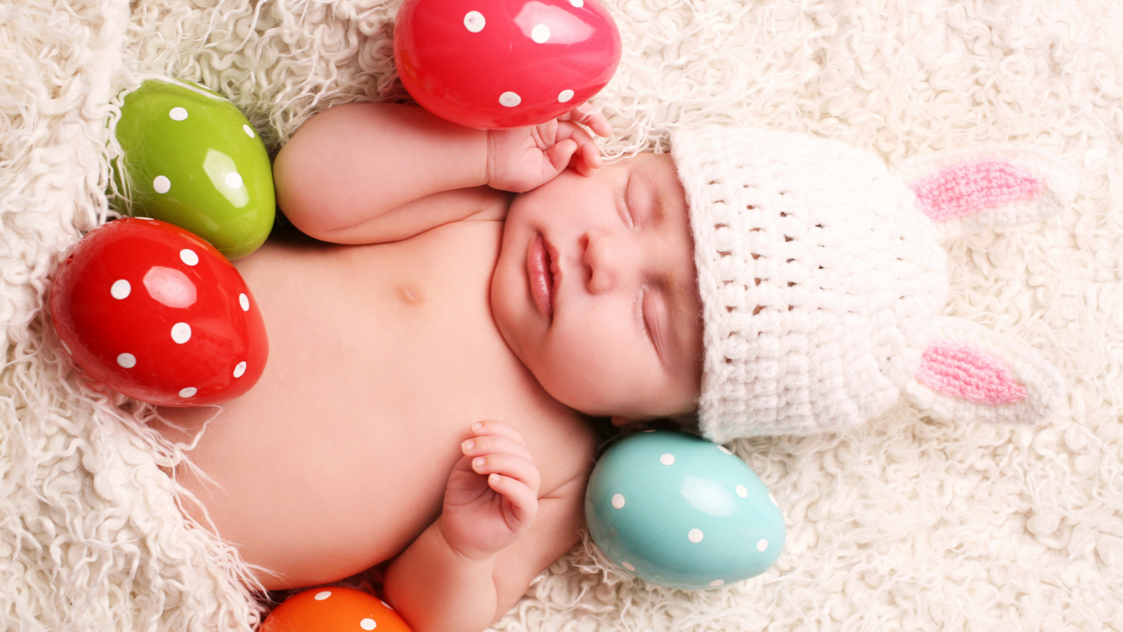 Маленький спящий ребенок с пасхальными яйцами