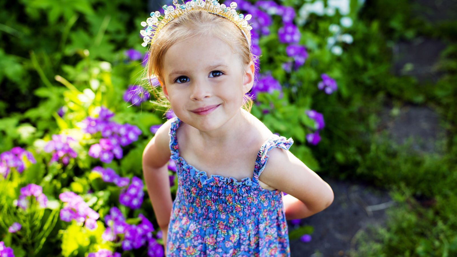 Маленькая улыбающаяся девочка с украшением в волосах 