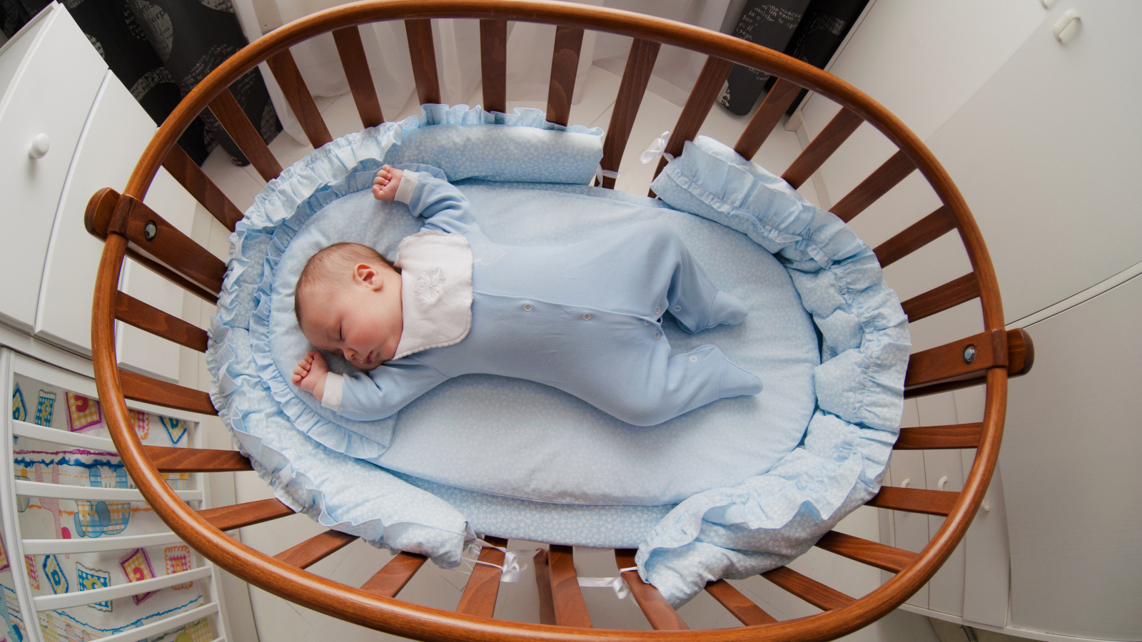 Спящий грудной ребенок в кроватке