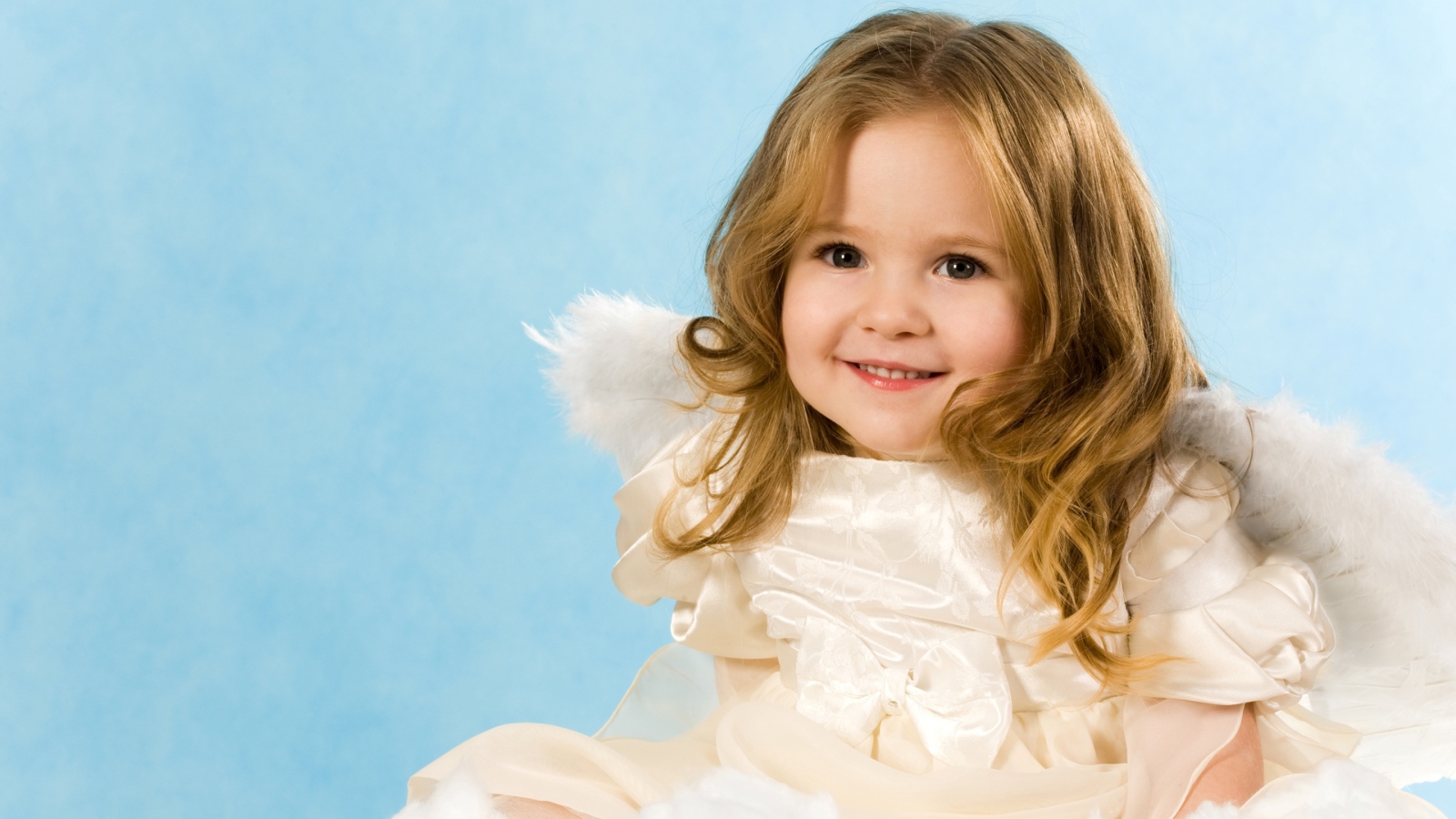 Улыбающаяся девочка с крыльями ангела