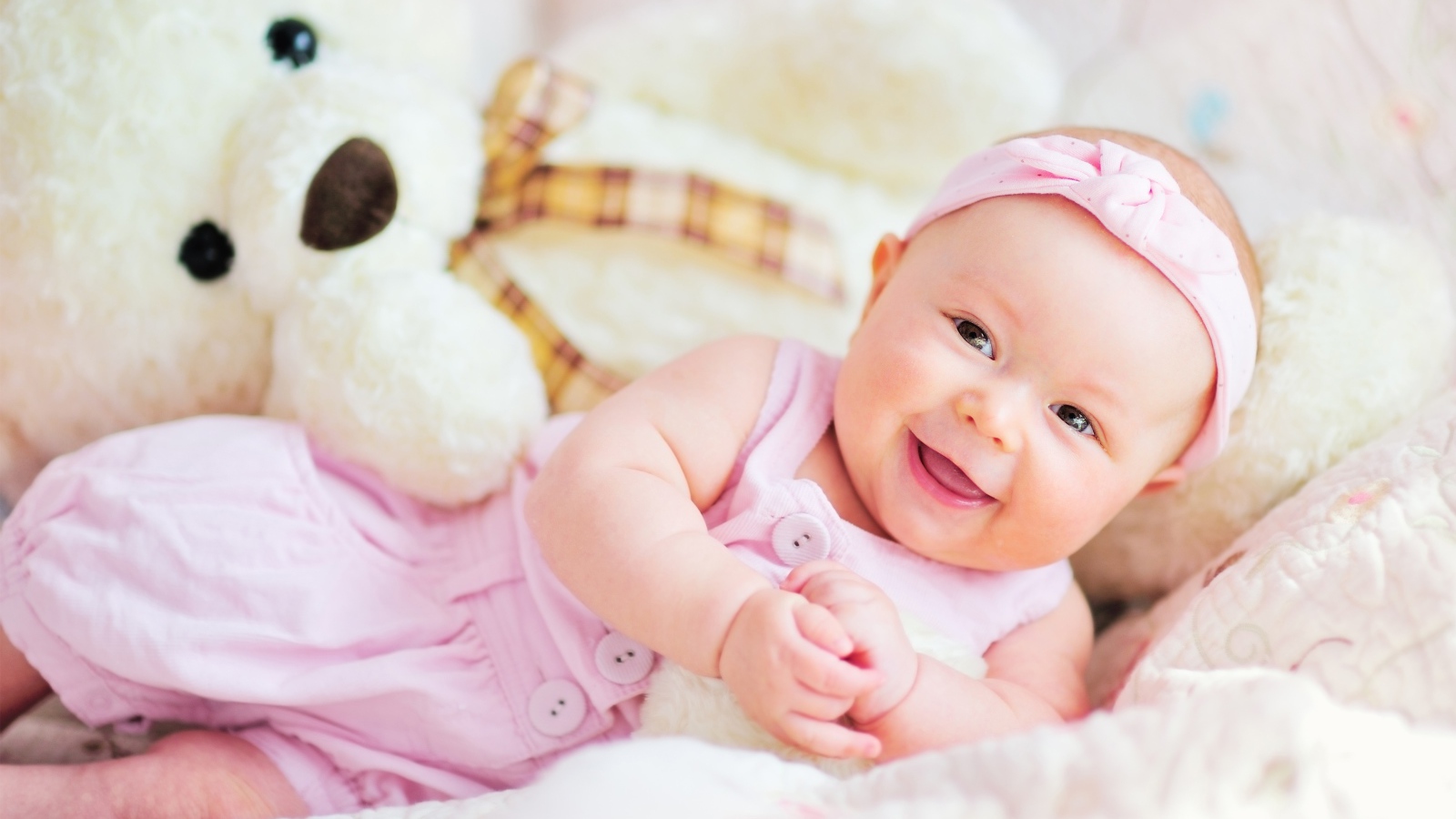 Улыбающаяся маленькая девочка с большим плюшевым медведем