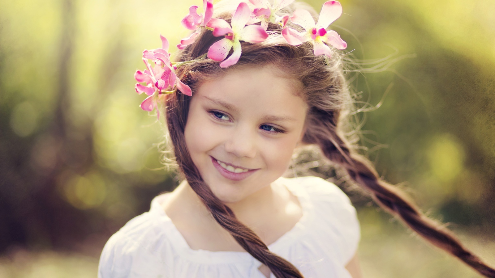 Улыбающаяся маленькая девочка с косичками