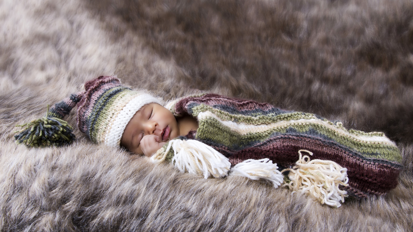 Младенец спит на меховом покрывале