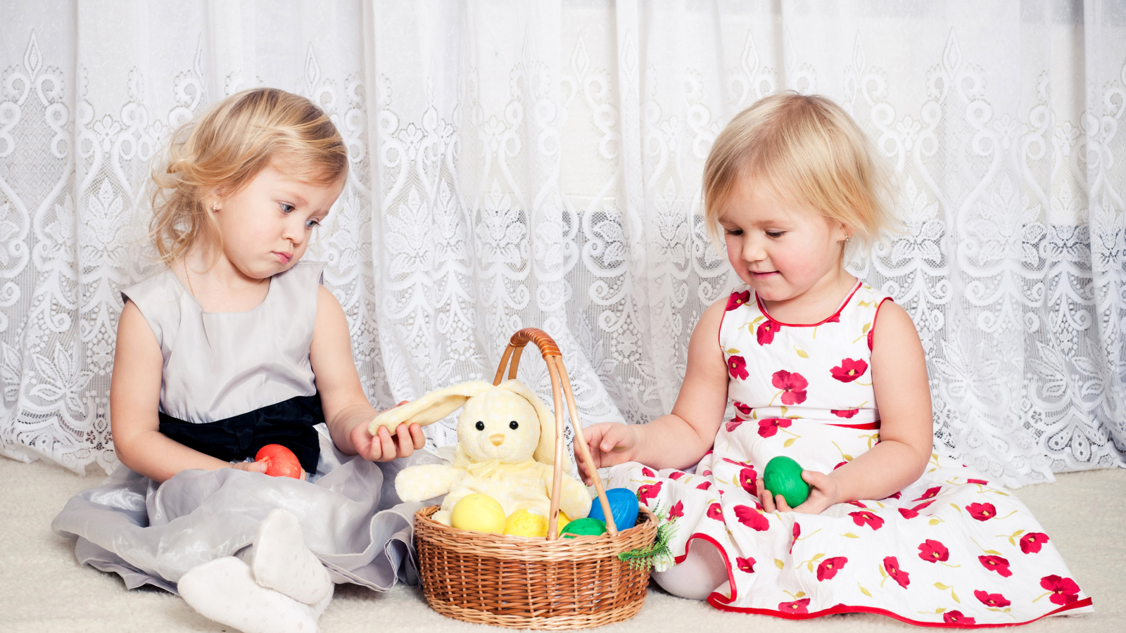 Две маленькие девочки с корзиной пасхальных яиц
