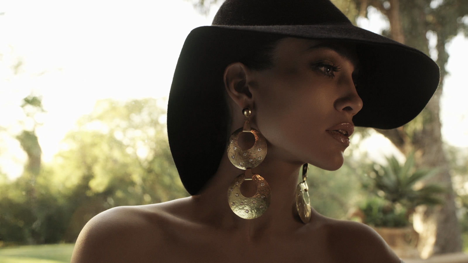 Актриса Дженнифер Лопес в большой черной шляпе