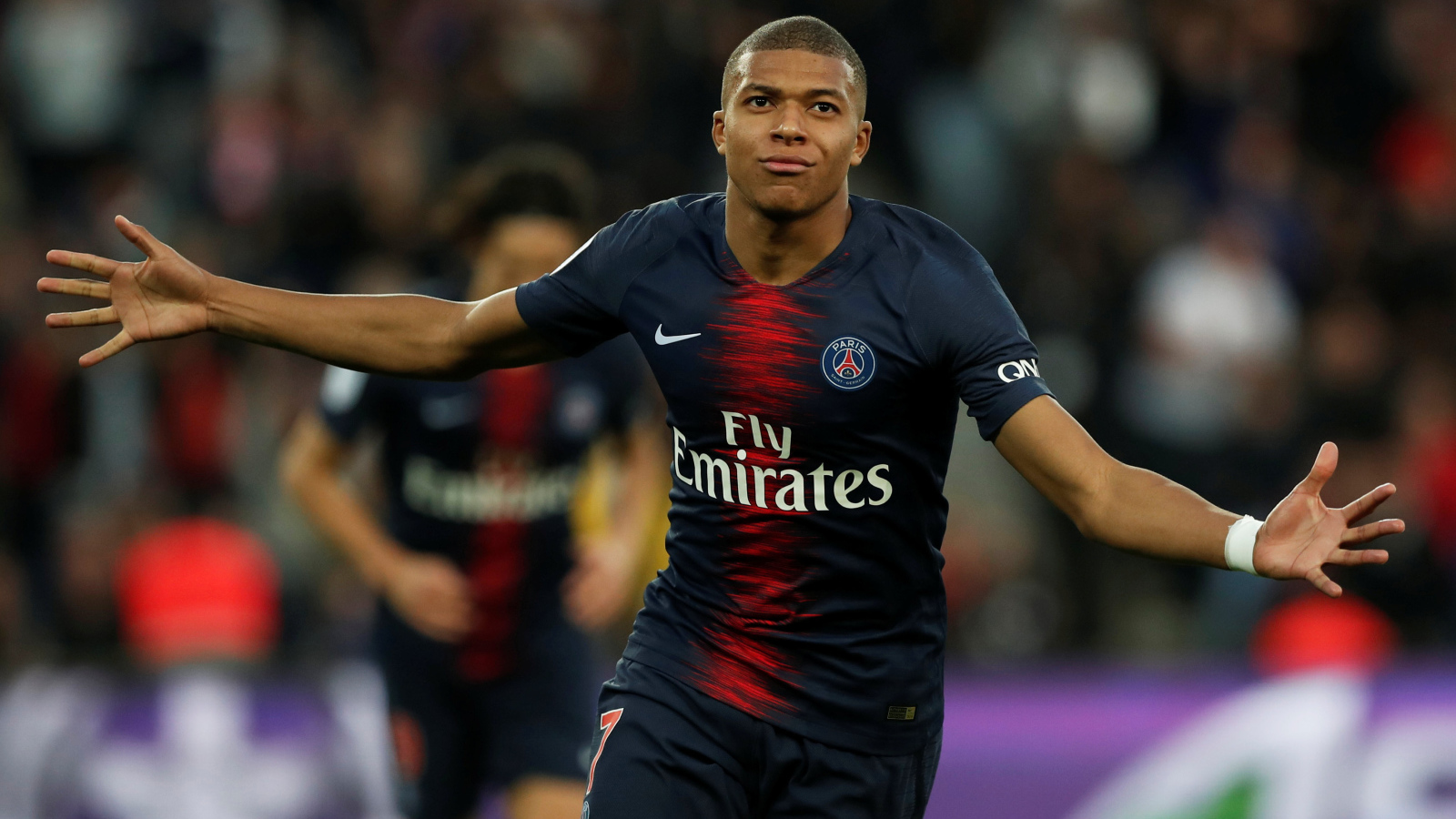 Французский футболист Килиан Мбаппе бежит по полю